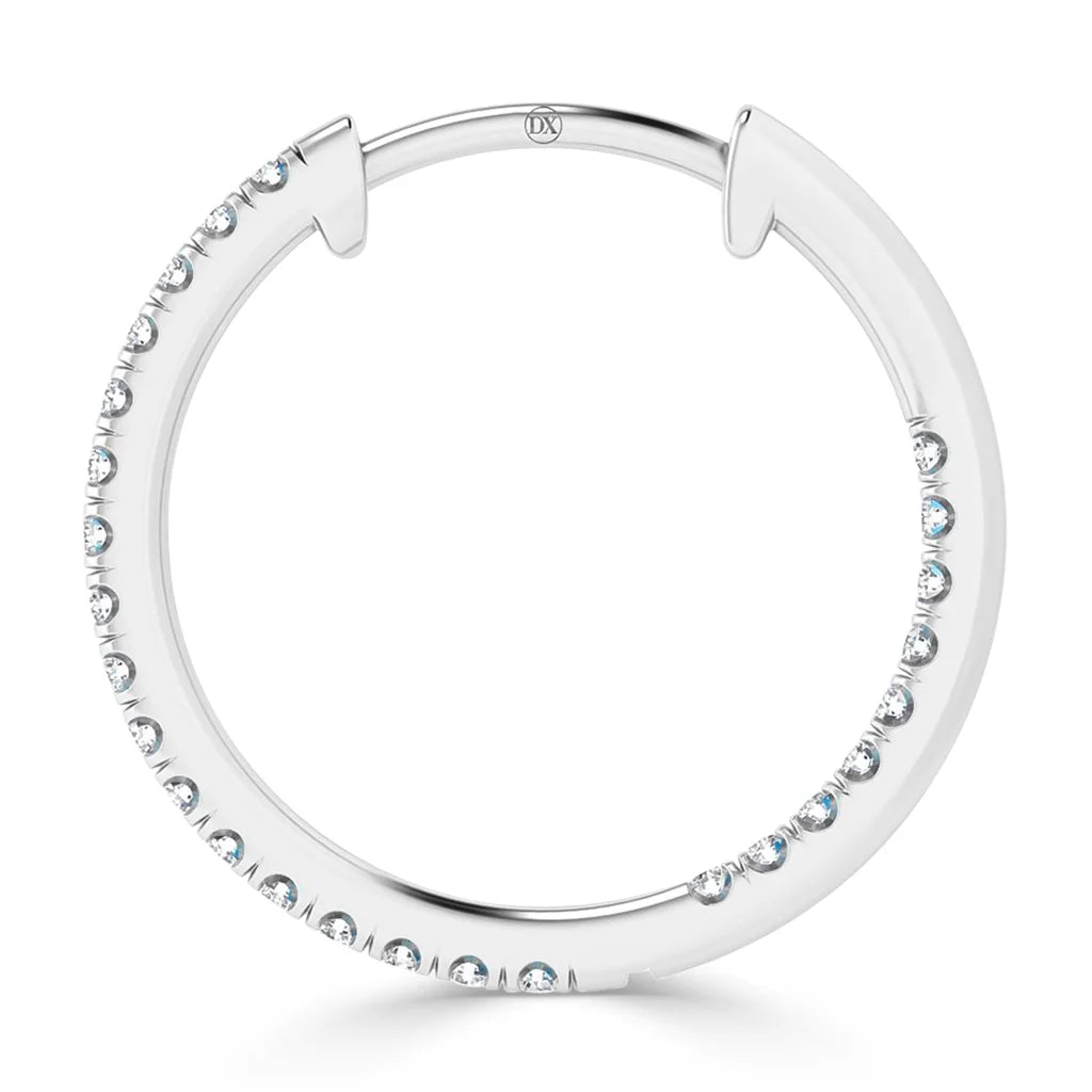 A round silver hoop earring with small, evenly spaced clear gemstones embedded along the outer edge.