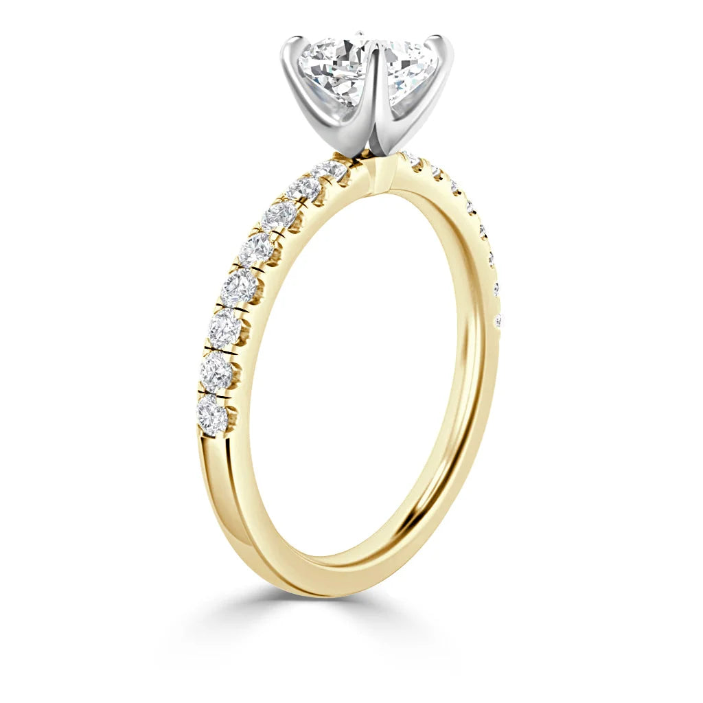 Gold ring with diamonds on the band and a large round diamond in a prong setting at the top.