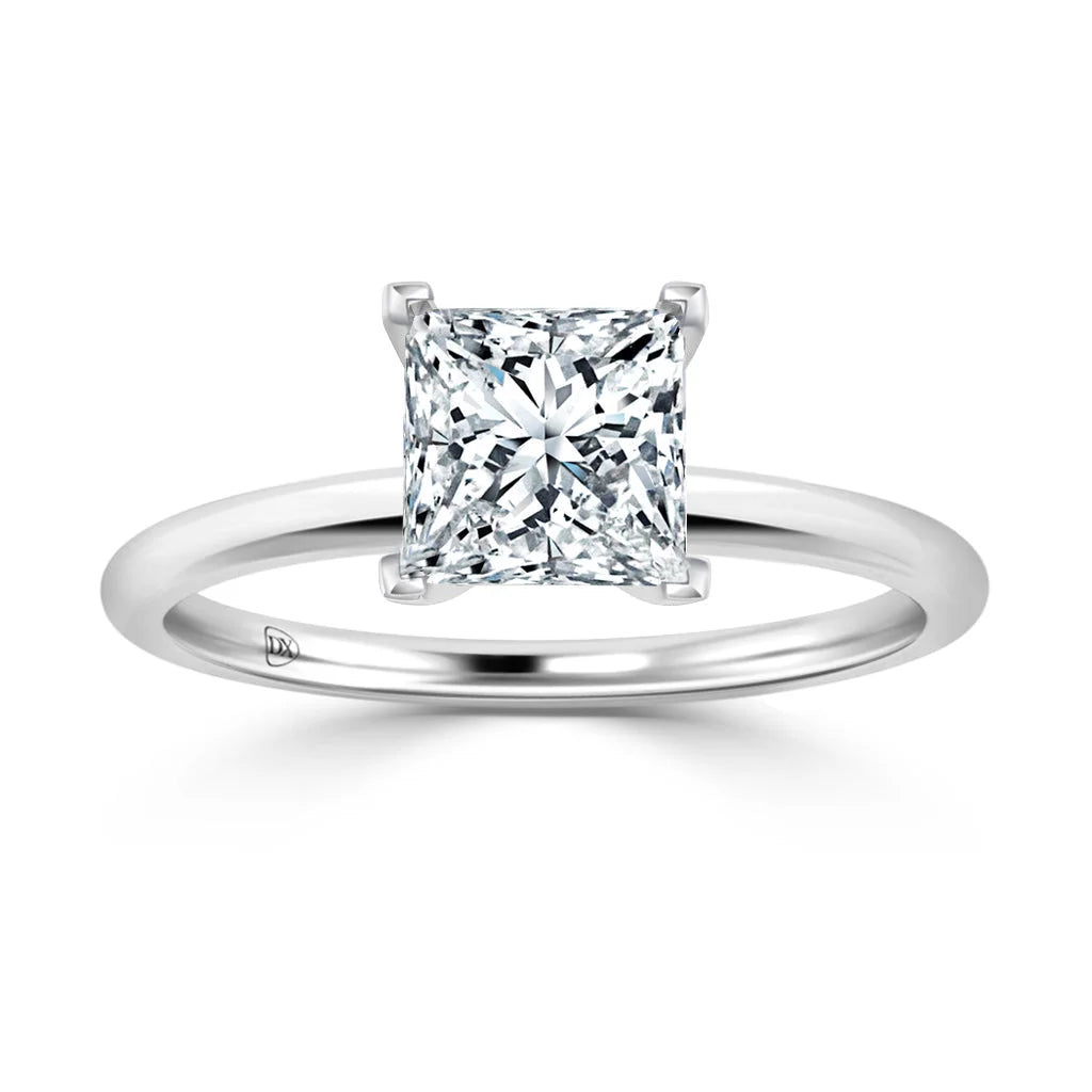 A solitaire ring with a princess-cut diamond set on a simple, polished white gold band.