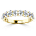 A gold ring with a row of round, sparkling diamonds set across the top half of the band.