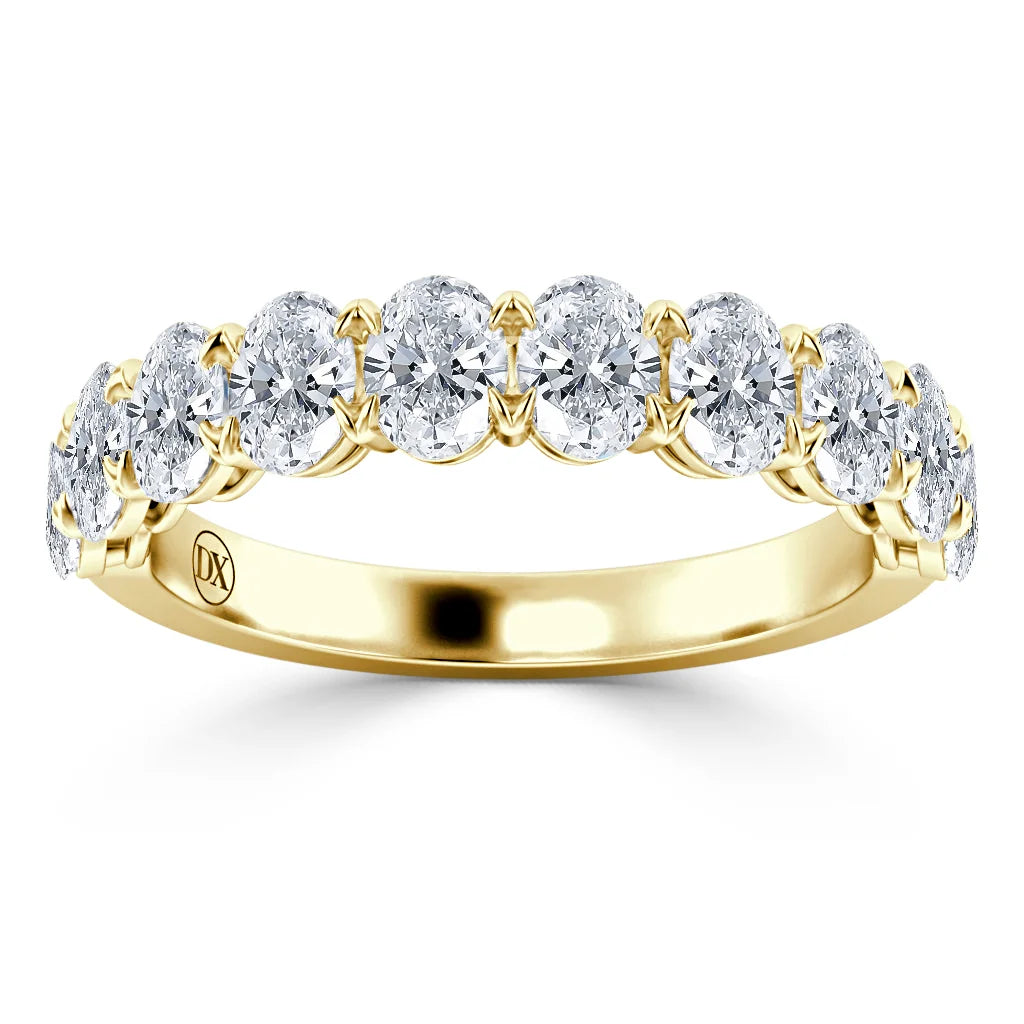 A gold ring with a row of round, sparkling diamonds set across the top half of the band.