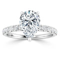 A pear-shaped diamond ring with a pavé-set diamond band on a white gold setting.