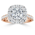 A cushion-cut diamond ring with a halo of smaller diamonds on a rose gold band, set against a white background.