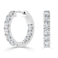 Pair of silver hoop earrings adorned with round, white sparkling diamonds set in a row along the front.