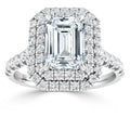 A white gold ring with an emerald-cut center diamond, double halo, and pavé diamond band.