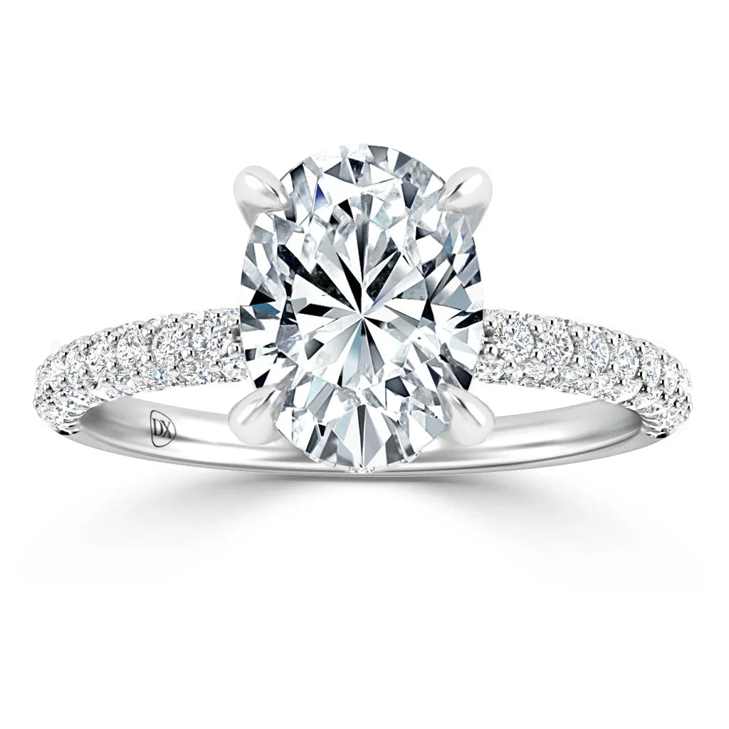 Oval-cut diamond ring with a pavé band and four prongs on a white background.