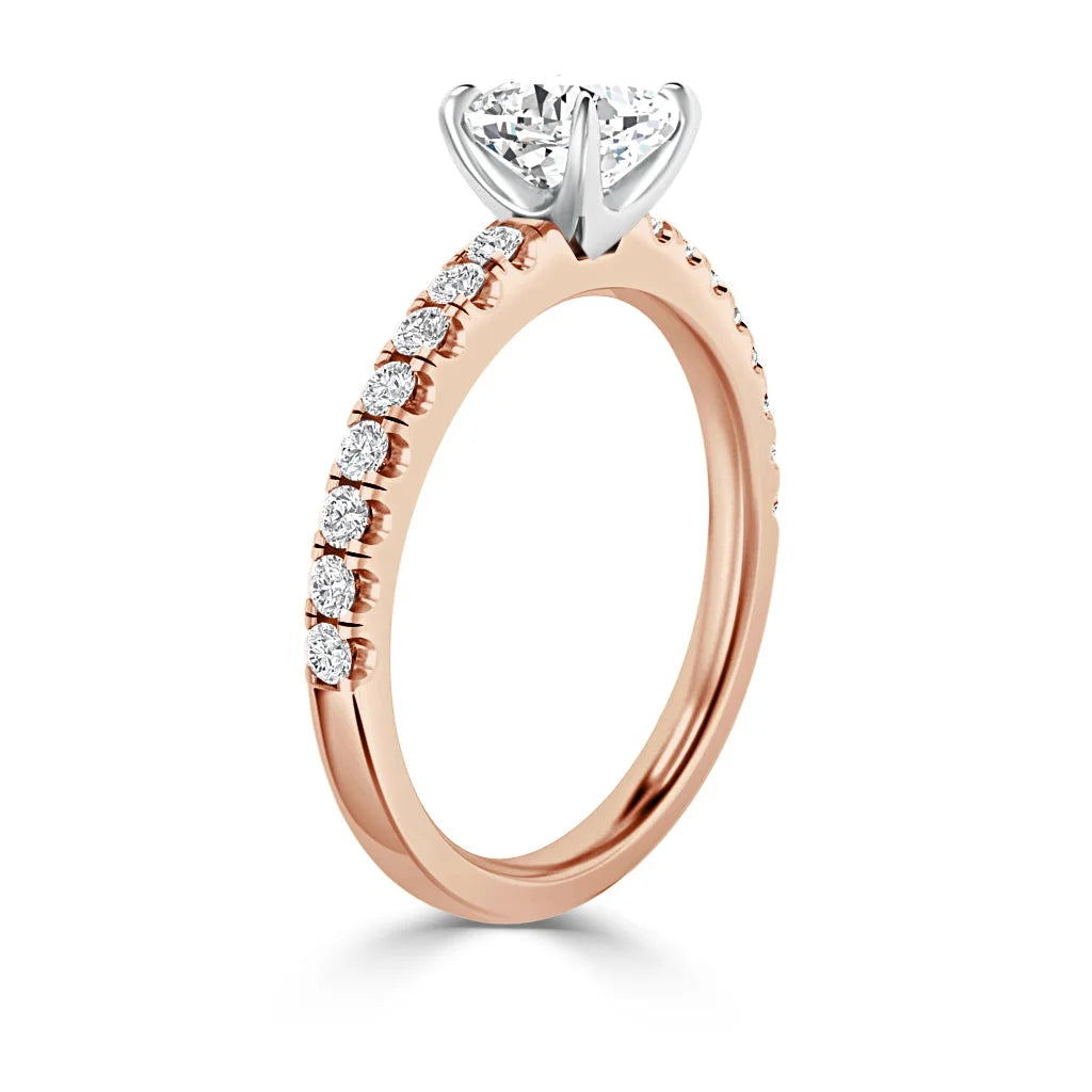 Rose gold ring with diamond pavé band and a large solitaire diamond in a white gold prong setting.