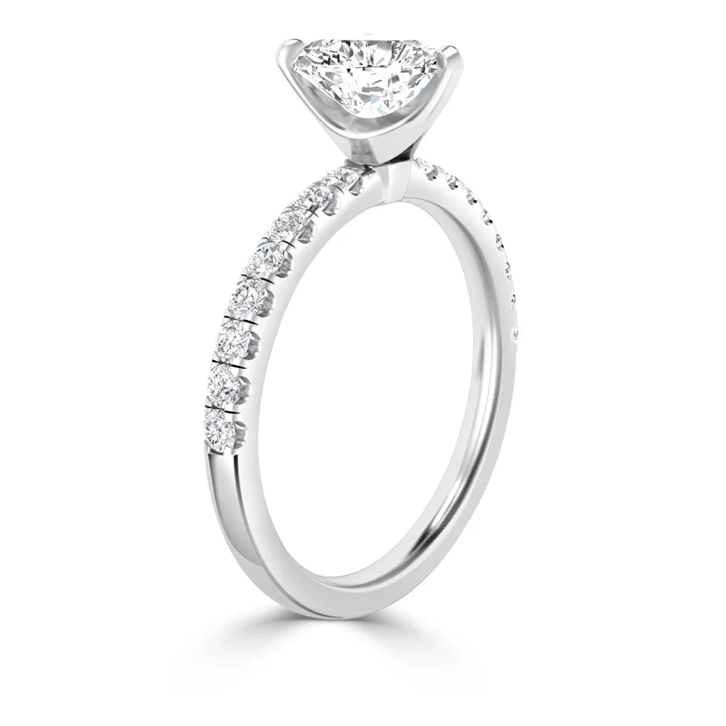 A white gold engagement ring with a round center diamond and smaller diamonds set along the band.