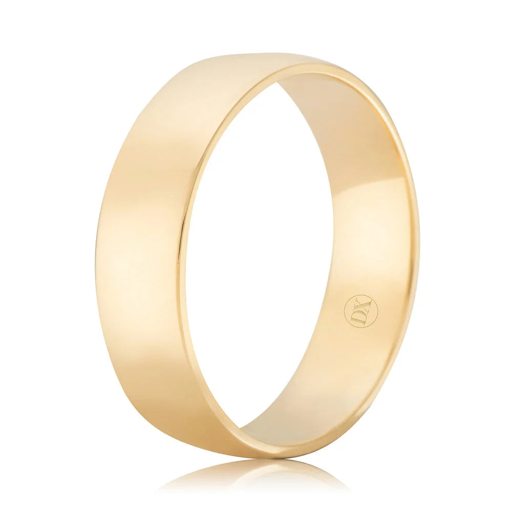 A simple, polished gold band ring with a smooth surface and a small engraved symbol inside.