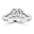 A silver ring with a split shank design and a cushion-cut diamond solitaire set in four prongs.