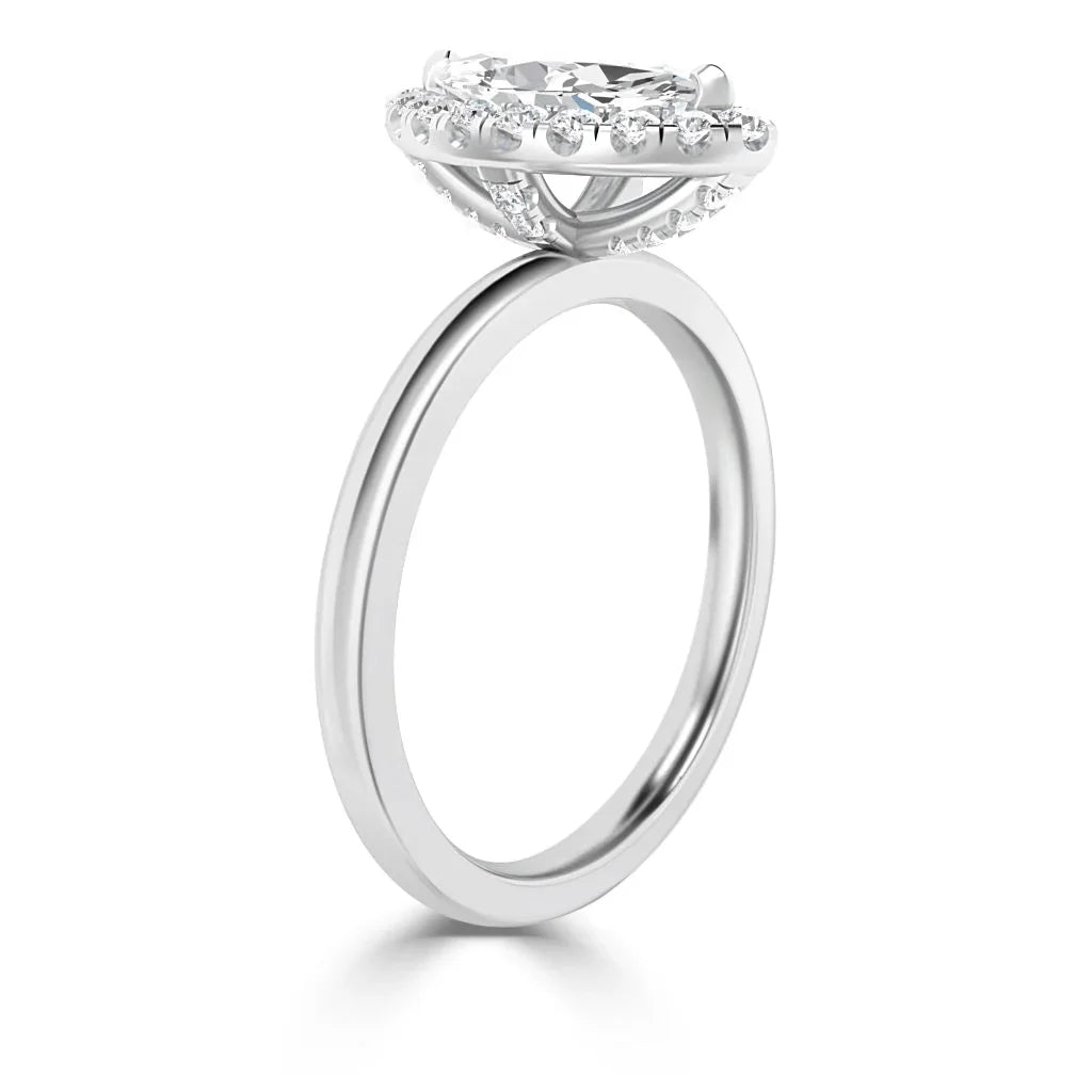 A silver halo engagement ring with a large central diamond and smaller diamonds around the band’s setting.
