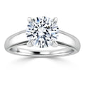 Solitaire diamond ring with a round brilliant-cut stone set in a four-prong platinum band, on white background.
