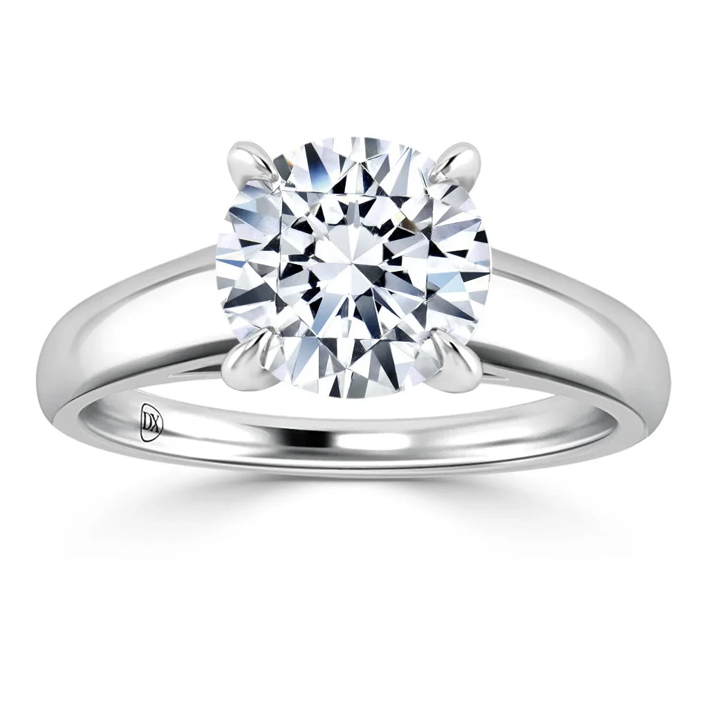 Solitaire diamond ring with a round brilliant-cut stone set in a four-prong platinum band, on white background.