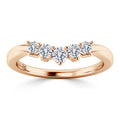 A rose gold ring with five round, white diamonds set in a row across the band.
