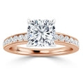 Rose gold ring with a cushion-cut diamond center and smaller diamonds set along half of the band.