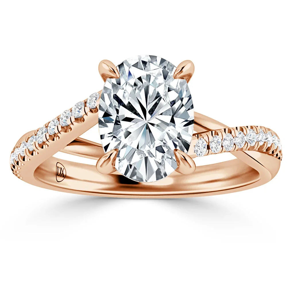 Rose gold ring with split band, pavé diamonds, and a large oval-cut center diamond on top.