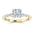 Gold ring with a cushion-cut center diamond and marquise side stones, featuring an engraved DX on the band.
