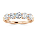 A rose gold ring with five round, white diamonds set in a row along the band.