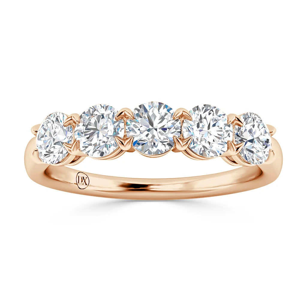A rose gold ring with five round, white diamonds set in a row along the band.