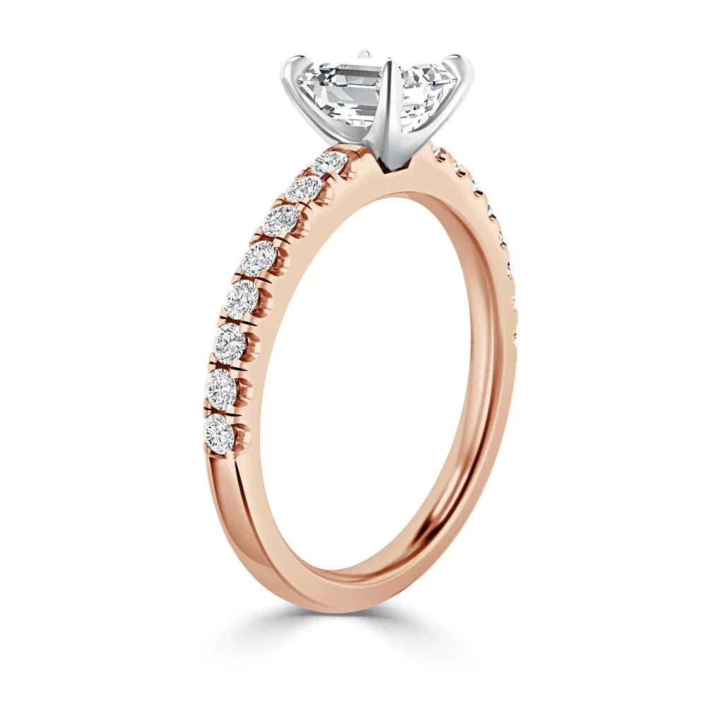 Rose gold ring with small diamonds on the band and a large solitaire diamond in a prong setting.