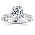 Oval-cut diamond ring with side diamonds on a silver band, shown from the front on a white background.