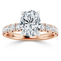 Rose gold ring with an oval-cut diamond center and round diamonds set along the band.