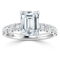 Emerald-cut diamond ring with a pavé band set with round diamonds on a platinum setting.
