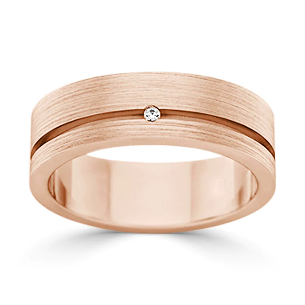 A rose gold ring with a brushed finish, a central groove, and a single small diamond set in the middle.