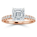 Rose gold ring with a large square-cut diamond and small round diamonds along the band.