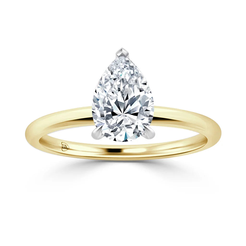 A pear-shaped diamond solitaire on a thin, polished yellow gold band against a white background.