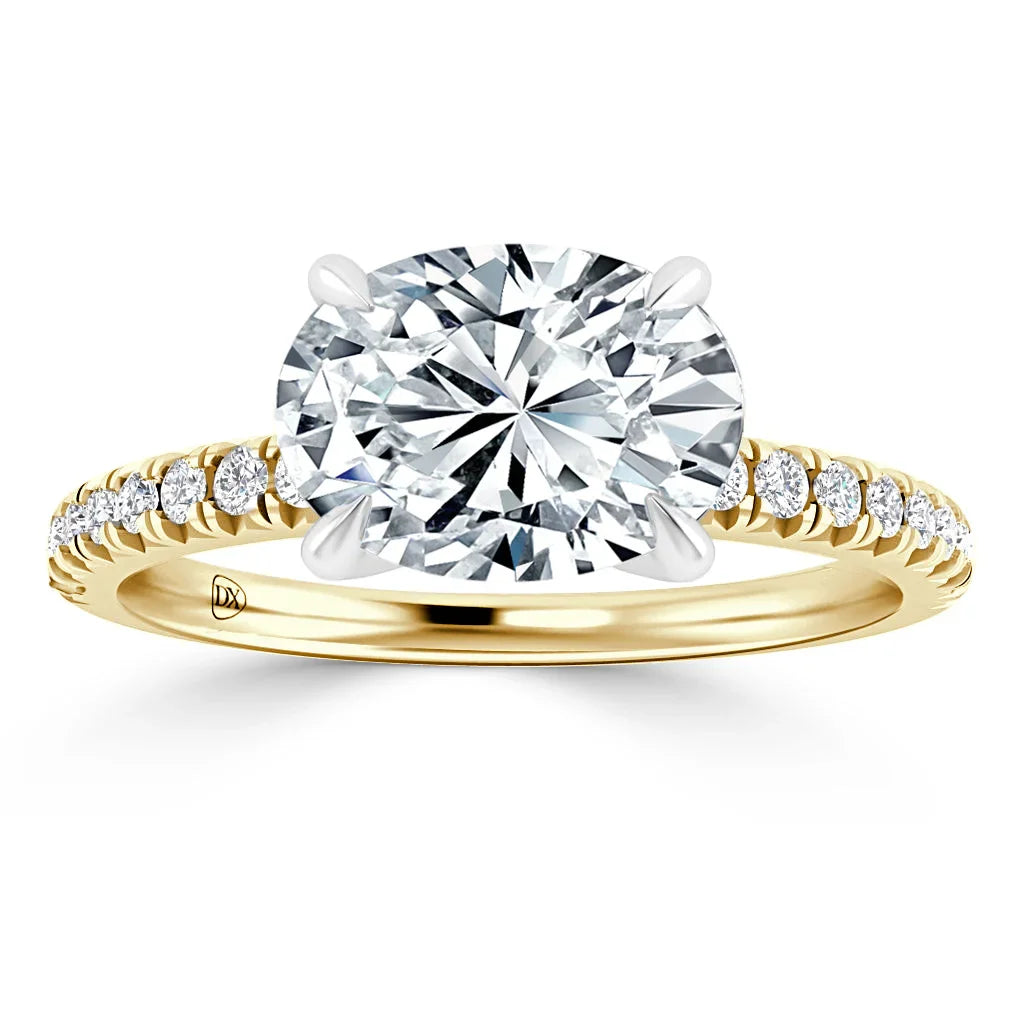 Gold band engagement ring with a large oval diamond center and small diamonds along the band, on white background.