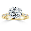 Gold band engagement ring with a large oval diamond center and small diamonds along the band, on white background.