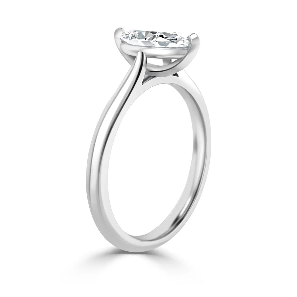 A sleek solitaire engagement ring with a round diamond in a modern, minimalist four-prong setting.