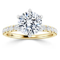 Gold engagement ring with a large round diamond center and smaller diamonds along the band.