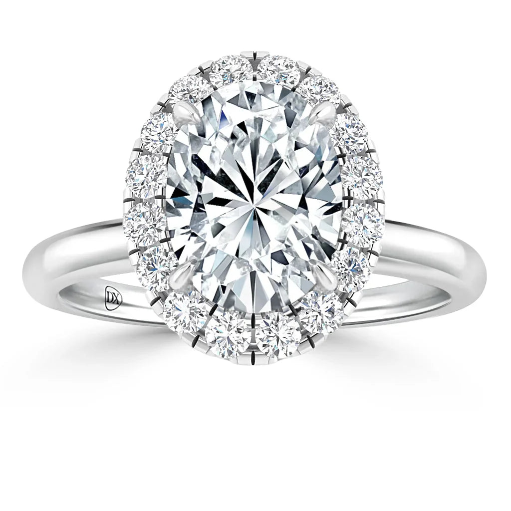 Oval diamond ring with a halo of small diamonds set on a shiny silver band, shown from the top view.