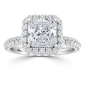 Square-cut diamond ring with a double halo and pave diamonds on the band, set in white metal.