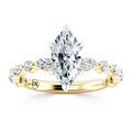 Gold ring with a large marquise-cut diamond and smaller side diamonds set in a twisted band design.