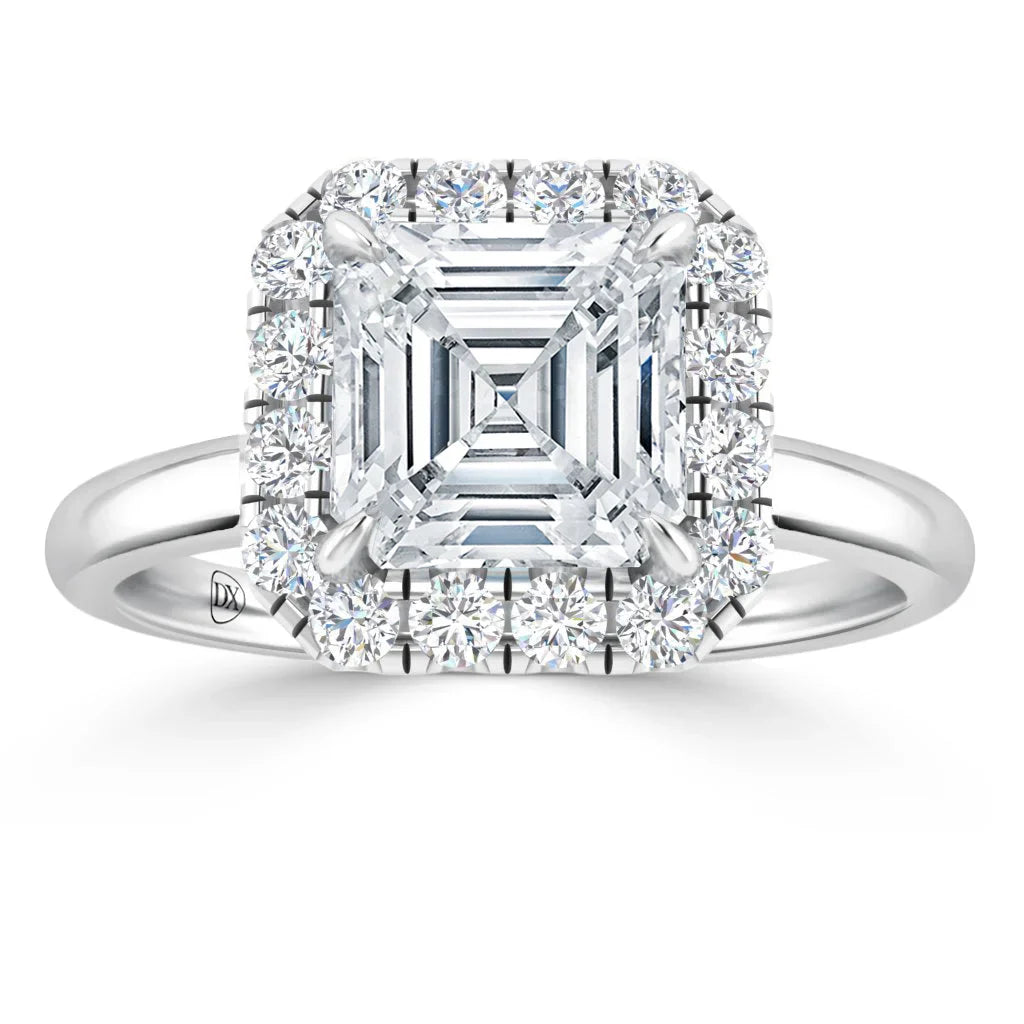 White gold ring with a square-cut center diamond, haloed by smaller round diamonds, on a polished band.