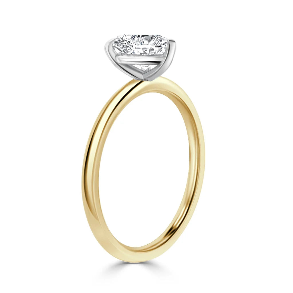 Gold band ring with a round solitaire diamond in a white gold prong setting, shown on a white background.