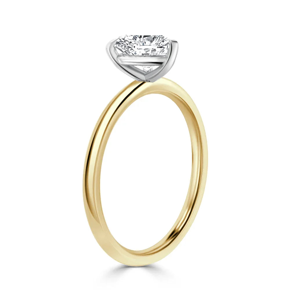 Gold band ring with a round solitaire diamond in a white gold prong setting, shown on a white background.