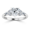 White gold ring with a heart-shaped diamond center and four smaller round and pear-cut side diamonds.