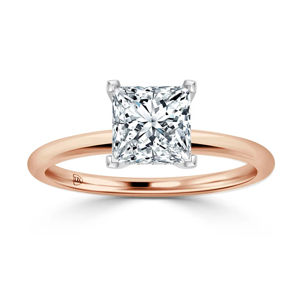A rose gold ring with a large princess-cut diamond solitaire set in a simple, elegant band.