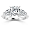 Platinum ring with a large center round diamond and two smaller side diamonds on a polished band.
