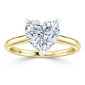 Gold ring with a heart-shaped diamond solitaire secured by three prongs, displayed on a white background.
