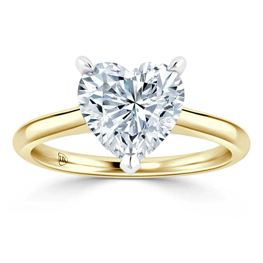 Gold ring with a heart-shaped diamond solitaire secured by three prongs, displayed on a white background.
