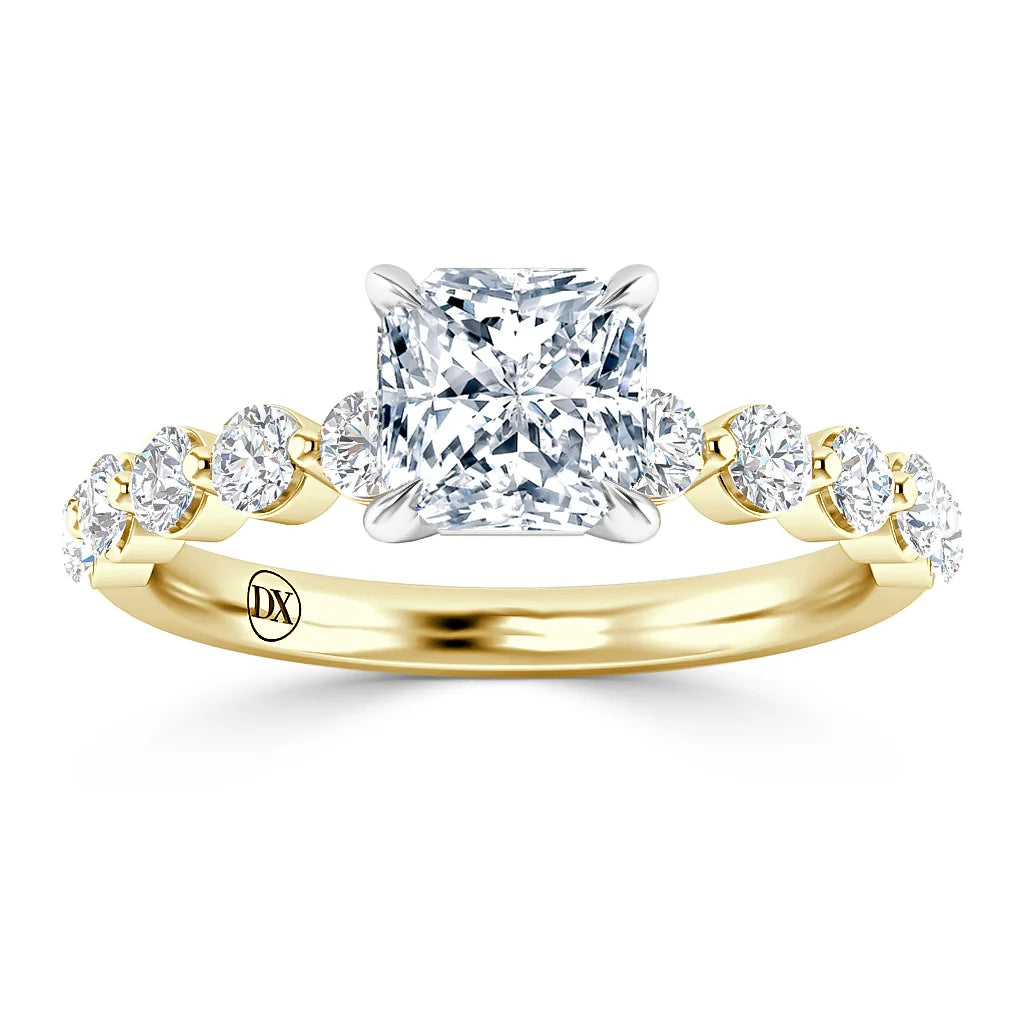 A gold ring with a large square diamond center and round diamonds on the band, viewed from the front.