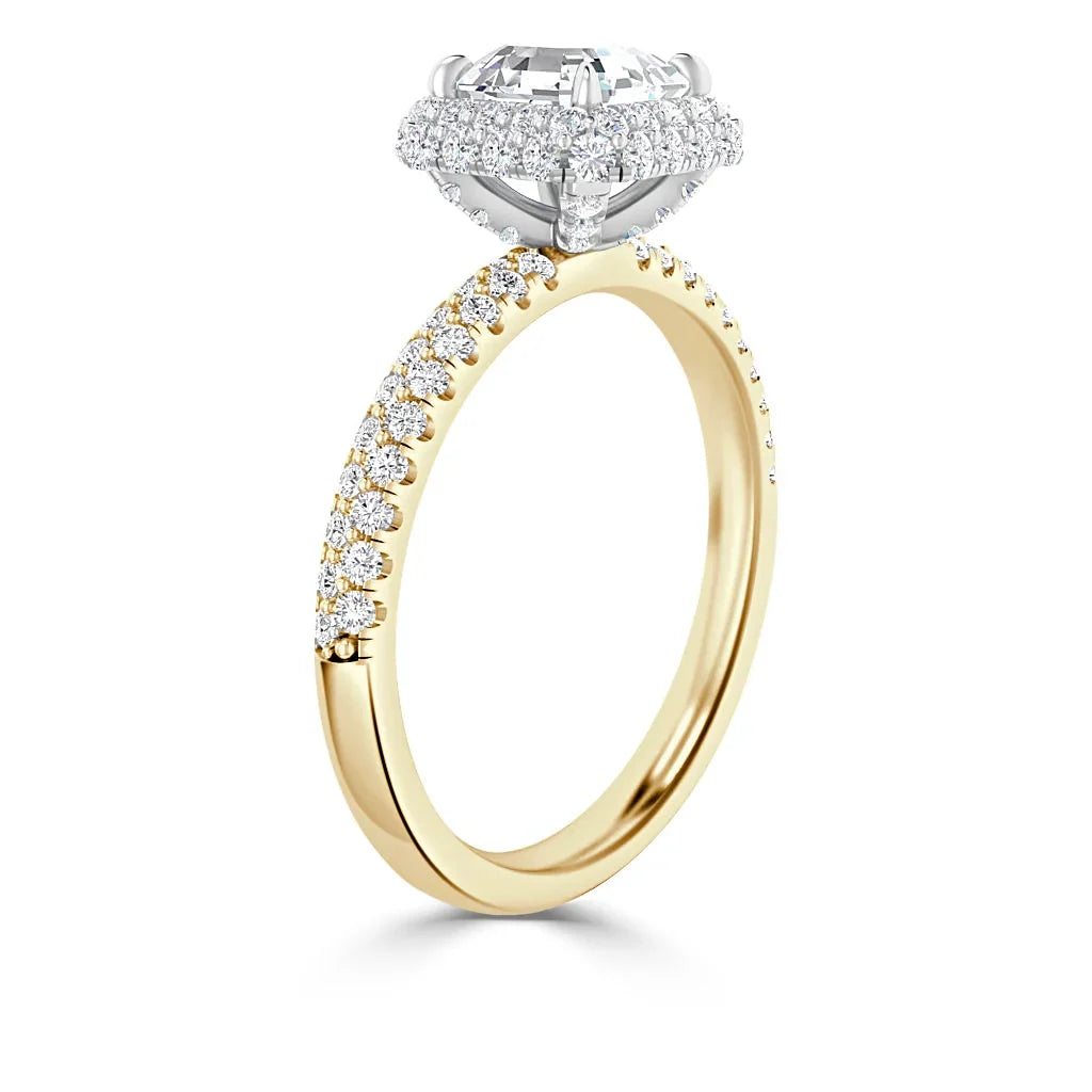 A gold ring with a large round diamond center stone and pavé diamonds along the band and setting.
