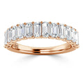 A rose gold ring set with a row of rectangular emerald-cut diamonds across the band.