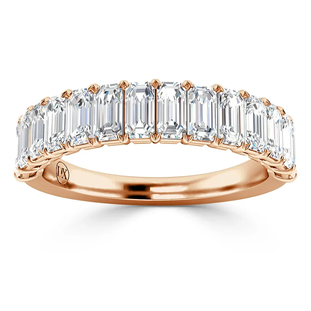 A rose gold ring set with a row of rectangular emerald-cut diamonds across the band.