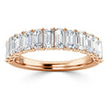 A rose gold ring set with a row of rectangular emerald-cut diamonds across the band.